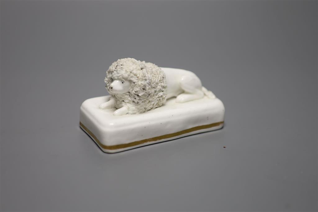A Staffordshire porcelain poodle, recumbent on rectangular cushion base, c.1850, length 10cm